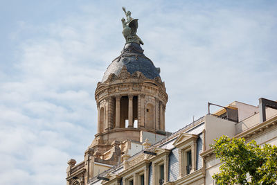 The dome and top statues of la union and el fenix on passeig de gracia, barcelona - spain.