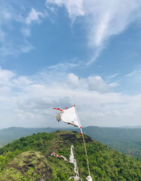 Low angle view of flag on mountain against sky