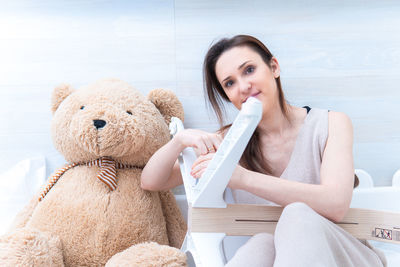 Portrait of woman sitting with toy