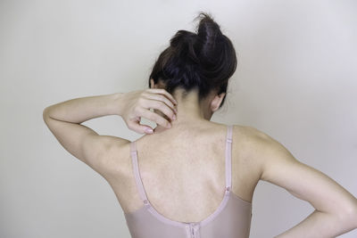 Rear view of shirtless woman against white background