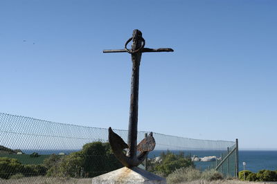 Low angle view of cross against clear blue sky