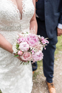 Midsection of woman holding flower bouquet