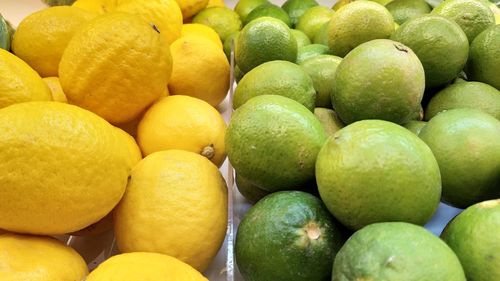 Full frame shot of limes and lemons for sale at market