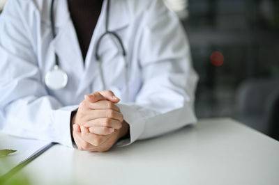 Midsection of doctor writing on paper