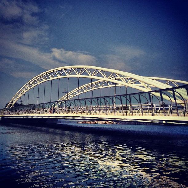 built structure, architecture, connection, bridge - man made structure, water, engineering, waterfront, sky, blue, bridge, river, transportation, low angle view, travel destinations, suspension bridge, outdoors, rippled, travel, cloud - sky, famous place