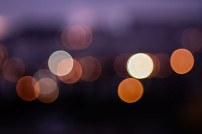 Defocused image of lights against sky at night