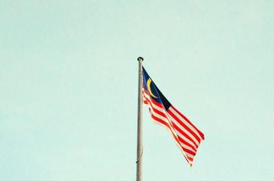 Low angle view of flag flags against clear sky