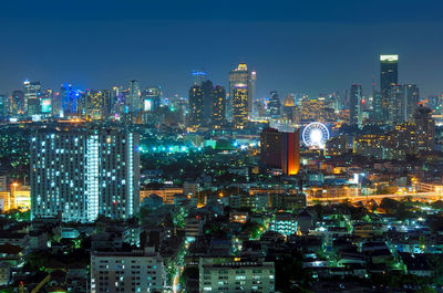 Illuminated cityscape against sky at night