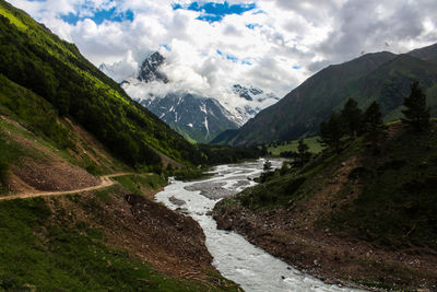 Scenic view of river amidst mountains against sky