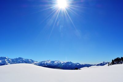Scenic view of snowcapped mountains against blue sky
