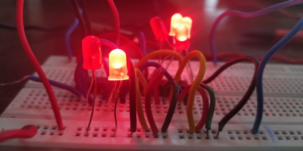 Close-up of illuminated lights amidst cables in dark