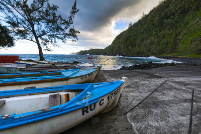 Boat moored on beach against sky