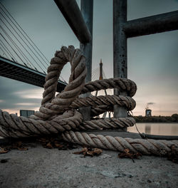 Close-up of rope tied to railing against sky