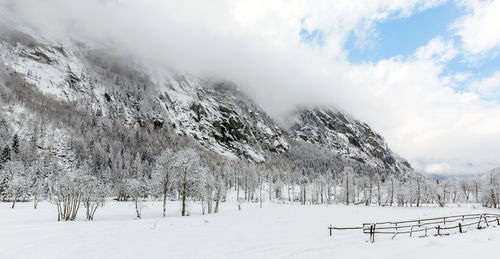 Snow covered land against sky during winter