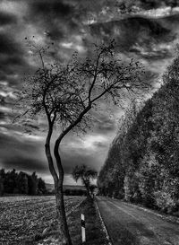 Road passing through landscape against cloudy sky