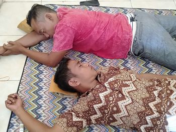 High angle view of siblings lying on floor