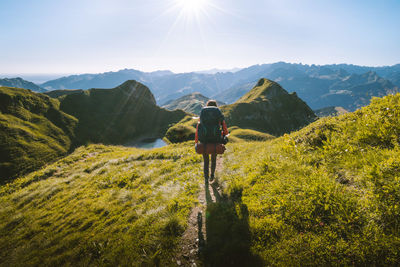 Rear view of man on mountain against sky