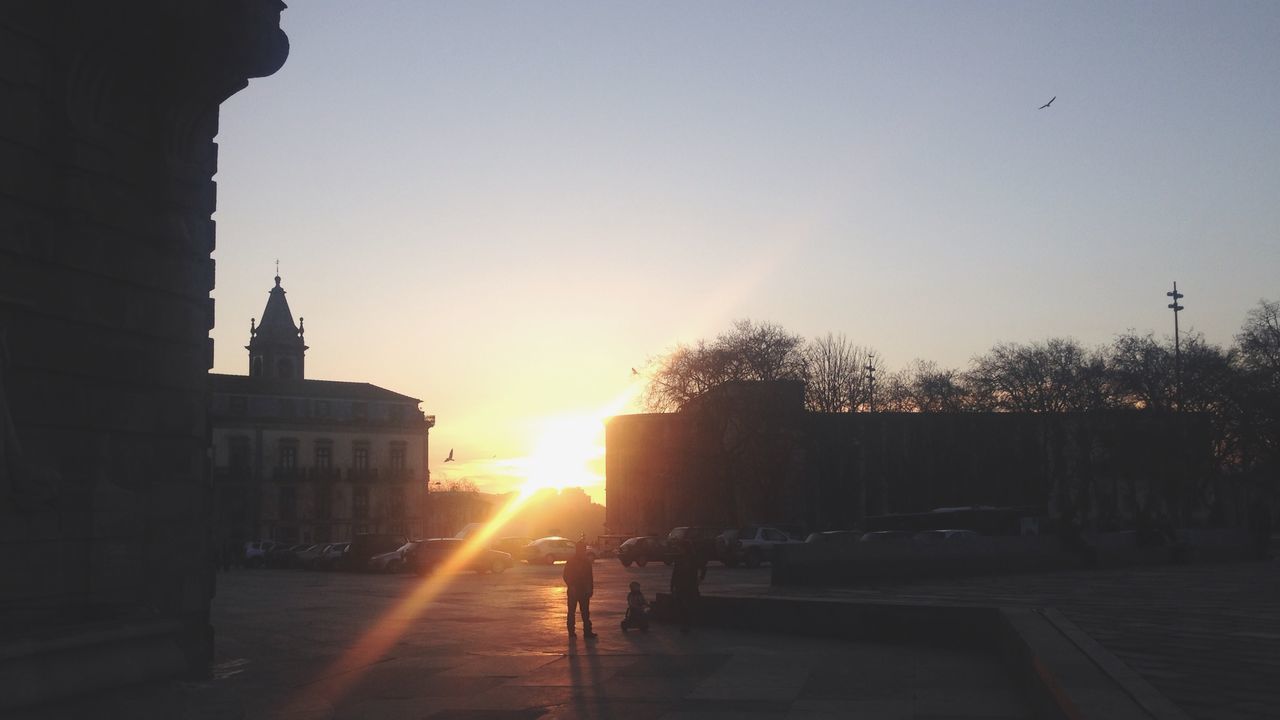 architecture, building exterior, built structure, sun, sunset, clear sky, sunlight, the way forward, copy space, silhouette, transportation, city, road, street, sunbeam, lens flare, outdoors, car, sky, incidental people