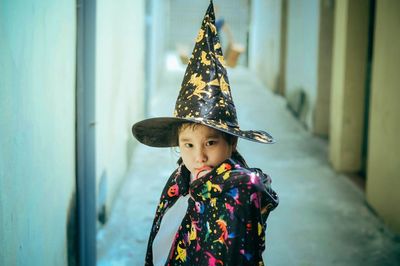 Full length of boy wearing hat against wall during halloween