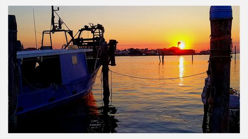 Boats in harbor at sunset