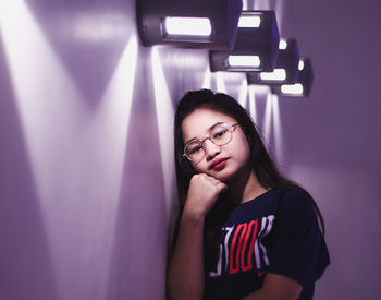 Portrait of woman standing against wall