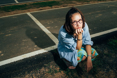 High angle view of girl sitting on road