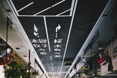 Low angle view of text on street against buildings in city