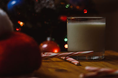 Close-up of drink by candy canes in glass on table