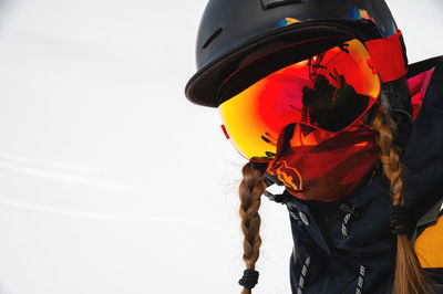 Portrait of a young woman in a ski resort against the backdrop of a snow-capped mountain, her