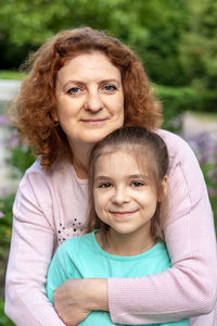 Portrait of a happy woman and daughter smiling and looking at the camera.