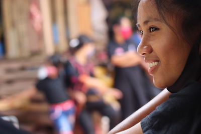 Close-up portrait of smiling young woman looking away outdoors