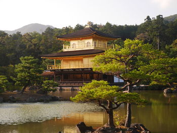 Building by lake against sky