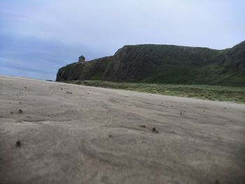 Surface level of sandy beach against sky