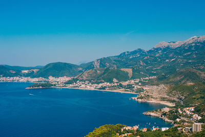 Scenic view of sea and mountains against blue sky