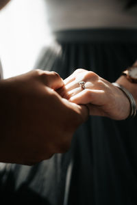 Midsection of couple holding hands