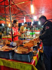 People at market stall at night