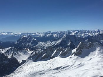 Scenic view of snowcapped mountains against clear blue sky