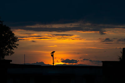 Silhouette buildings against sky during sunset