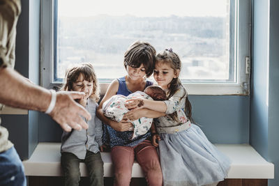 Funny image of siblings meeting newborn baby brother for first time