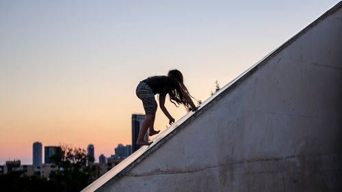 Side view of person against clear sky during sunset