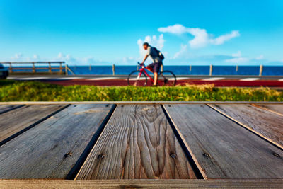 Man with bicycle on pier against sky