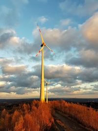 Wind turbine against sky during sunset