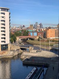 River amidst buildings in city against sky