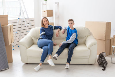 Portrait of smiling young man sitting on sofa at home