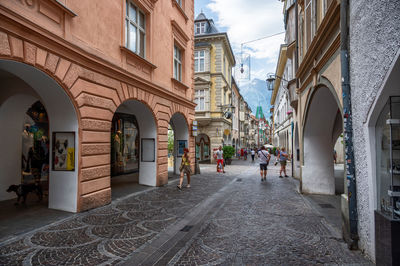 People walking on street amidst buildings in city