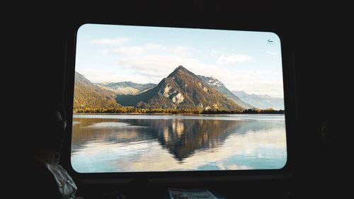 Scenic view of lake and mountains seen through window