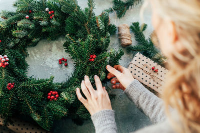 High angle view of woman making wreath on table