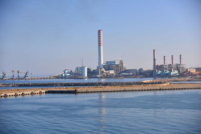 River by buildings against clear sky