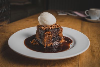 Close-up of ice cream on brownie in plate on table