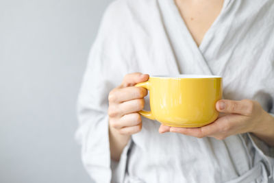 Midsection of woman holding coffee cup